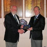 CHANGING OF THE GUARD: outgoing Harwich Golf Club captain Rod Osborne is presented with a gift by his successor, Gus Hales. For a full report, see page 39.