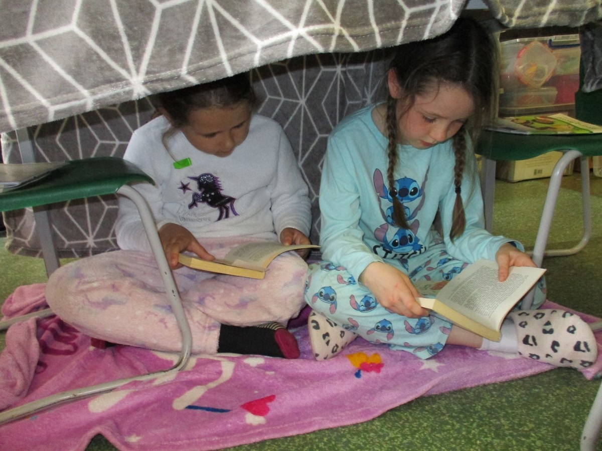 Book to basics - Lucy Rowbotham and Lola Brockman built a den in their classroom. They are pictured here reading under the table together