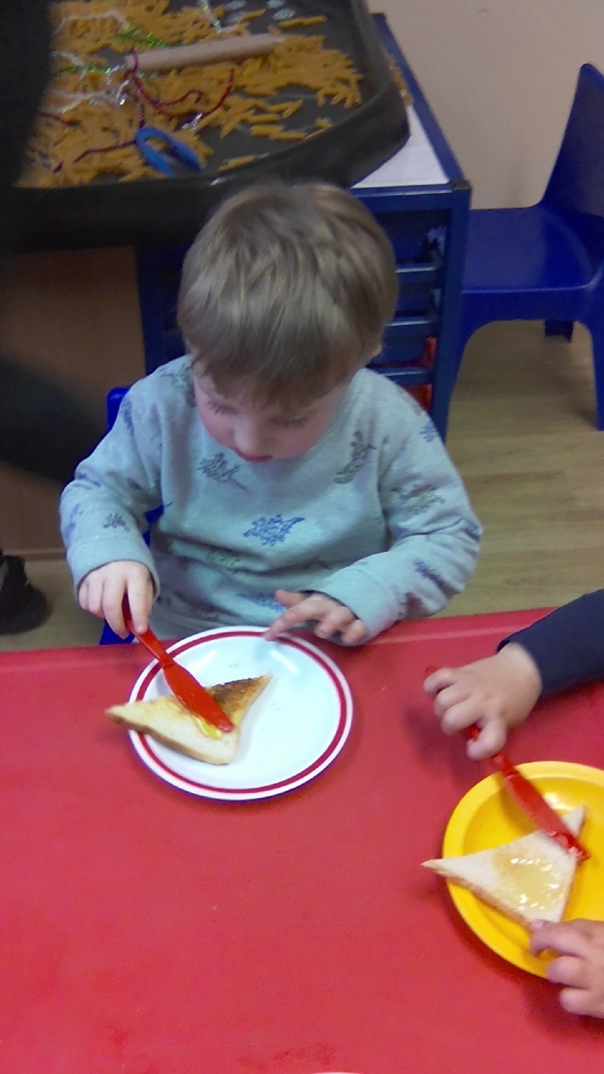 Sweet treat - Reece Dalton-Brockwell, in Nursery, uses his fine motor skills to spread honey on his toast during snack time