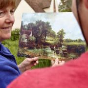 Visitors comparing Constable's paintings to the scene at Flatford