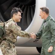 Welcome home - Brigadier James Martin (left) is greeted upon landing in the UK. Picture: PA