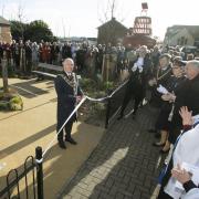 Town Mayor Ivan Henderson curs the ribbon to open the garden and memorial