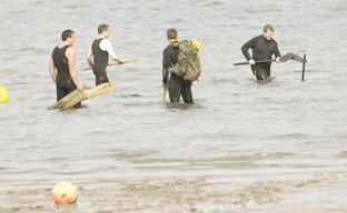 Bomb disposal team in action at Harwich Sailing club with WW2 V2 bomb in the mud.