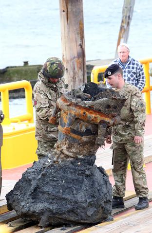 the remains of a ww2 V2 rocket is recovered from Harwich harbour on Saturday. Engineers take a look at the V2 when it reached Mistley Quay