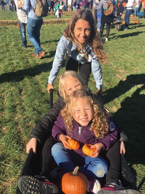 Wheelie fun - Sisters wheeling around the pumpkin patch 